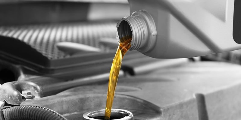Image of oil being poured into an engine